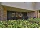 Brick patio with sliding glass doors leading to the interior, surrounded by greenery at 36750 Us Highway 19 # 23-110, Palm Harbor, FL 34684