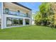 Beautiful backyard with glass-paneled balcony, sliding glass doors, lush green lawn and tropical landscaping at 2721 17Th N Ave, St Petersburg, FL 33713
