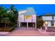 Evening view of pink two-story house with carport and landscaping at 20051 Gulf Blvd, Indian Shores, FL 33785