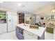 Open concept kitchen with white cabinets, purple island, and living room view at 20051 Gulf Blvd, Indian Shores, FL 33785
