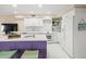 Modern kitchen with white cabinets, purple island, and mosaic backsplash at 20051 Gulf Blvd, Indian Shores, FL 33785