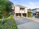 Pink two-story house with carport, landscaping, and waterfront view at 20051 Gulf Blvd, Indian Shores, FL 33785