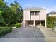 Pink two-story house with a carport and tropical landscaping at 20051 Gulf Blvd, Indian Shores, FL 33785