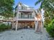 Unique elevated home with pink exterior and waterfront access at 20051 Gulf Blvd, Indian Shores, FL 33785