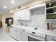 Modern kitchen with white cabinets, mosaic backsplash, and built-in range at 20051 Gulf Blvd, Indian Shores, FL 33785