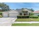 Two-story house with a three-car garage and manicured lawn at 1852 Longview Ln, Tarpon Springs, FL 34689