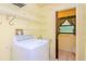 Laundry room with washer, shelving, and access to half bath at 15350 Scanio Dr, Spring Hill, FL 34610