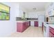 Galley kitchen with purple cabinets and white appliances at 15350 Scanio Dr, Spring Hill, FL 34610