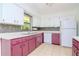 Bright kitchen featuring white and mauve cabinets, gray backsplash, and modern appliances at 15350 Scanio Dr, Spring Hill, FL 34610