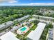 An aerial view of an apartment community with a swimming pool surrounded by trees and roads at 1433 S Belcher Rd # G10, Clearwater, FL 33764