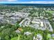 Expansive aerial view of a neighborhood with lush greenery, multiple pools, and convenient access to shopping centers at 1433 S Belcher Rd # G10, Clearwater, FL 33764