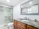 Bathroom featuring granite vanity, a glass-enclosed shower, and light fixtures at 1433 S Belcher Rd # G10, Clearwater, FL 33764