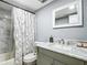 Bathroom with a white shower curtain, a marble countertop with silver-tone fixtures, and gray walls at 1433 S Belcher Rd # G10, Clearwater, FL 33764