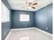 A well-lit bedroom with sleek, light-colored floors, blue accent walls, and a ceiling fan at 1433 S Belcher Rd # G10, Clearwater, FL 33764