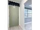 A home's entryway with a light-green front door, light-wood floors and a view to an adjacent room at 1433 S Belcher Rd # G10, Clearwater, FL 33764