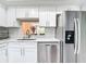 Modern kitchen with stainless steel appliances, white cabinets, a stylish backsplash, and a well-lit workspace at 1433 S Belcher Rd # G10, Clearwater, FL 33764