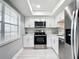 Bright kitchen featuring stainless steel appliances, white cabinetry, and light countertops with a window at 1433 S Belcher Rd # G10, Clearwater, FL 33764