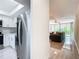 Open-concept living area with stainless steel fridge, leading to living room with cozy seating and natural light at 1433 S Belcher Rd # G10, Clearwater, FL 33764