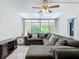 Spacious living room featuring a comfortable sectional sofa, ceiling fan, and sliding glass doors to the outdoors at 1433 S Belcher Rd # G10, Clearwater, FL 33764