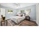 Bright bedroom features a ceiling fan, windows, wood floors, and stylish decor at 1549 Linwood Dr, Clearwater, FL 33755