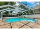 Inviting kidney-shaped pool with screened enclosure and patio chairs at 1549 Linwood Dr, Clearwater, FL 33755