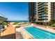 Outdoor pool with ocean view and high-rise buildings in the background at 1560 Gulf Blvd # 1004, Clearwater Beach, FL 33767