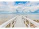 White wooden dock extending into calm, clear water at 2506 N Rocky Point Dr # 356, Tampa, FL 33607
