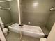 Small bathroom with a shower/tub combo and green tile at 1706 Belleair Forest Dr # 214, Belleair, FL 33756