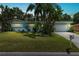 Ranch style home with teal exterior, well manicured lawn, and palm trees at dusk at 1549 Linwood Dr, Clearwater, FL 33755