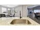 Kitchen with granite countertops, stainless steel sink, and view to Gathering room at 10208 Grove Dr, Port Richey, FL 34668