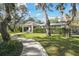 Ranch style home with covered entry, lush landscaping, and mature trees at 10208 Grove Dr, Port Richey, FL 34668