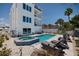 Beautiful backyard featuring pool, spa, patio with chairs, and lush landscaping at 2 4Th Ave, Indian Rocks Beach, FL 33785