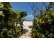 Charming beach access path framed by lush greenery, leading to a sandy shore at 2 4Th Ave, Indian Rocks Beach, FL 33785