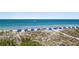 An elevated view of a sandy beach with rows of blue beach umbrellas and a boat in the distance at 2 4Th Ave, Indian Rocks Beach, FL 33785