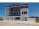 Modern three-story home showcasing a sleek design with a rooftop deck and an attached three-car garage at 2 4Th Ave, Indian Rocks Beach, FL 33785