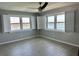 Comfortable bedroom featuring modern fan, wood-look floors, and bright windows with beautiful waterfront views at 7200 Sunshine Skyway S Ln # 7E, St Petersburg, FL 33711