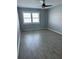 Neutral bedroom features wood-look flooring, bright window, and ceiling fan at 7200 Sunshine Skyway S Ln # 7E, St Petersburg, FL 33711