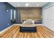Bright bedroom with wood-paneled accent wall, ceiling fan, and light wood flooring at 4822 3Rd S Ave, St Petersburg, FL 33711