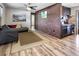 Living room features a sectional sofa, brick accent wall, and laminate wood floors at 4822 3Rd S Ave, St Petersburg, FL 33711