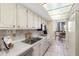 Clean kitchen area with bright white cabinetry, stainless steel sink, and tile backsplash at 660 Island Way # 401, Clearwater, FL 33767