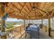 Waterfront dining area under a tiki hut with wood floors and seating for eight offers a charming spot to enjoy waterfront views at 660 Island Way # 401, Clearwater, FL 33767