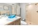 Stylish bathroom with a unique blue glass sink and walk-in shower at 9415 Blind Pass Rd # 803, St Pete Beach, FL 33706