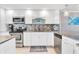White shaker cabinets, granite counters, stainless steel appliances in this kitchen at 9415 Blind Pass Rd # 803, St Pete Beach, FL 33706
