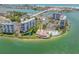 Aerial view of waterfront community with pool, tennis courts, and lush landscaping at 9415 Blind Pass Rd # 803, St Pete Beach, FL 33706