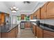 Bright kitchen with island, wood cabinets, granite countertops, and stainless steel appliances at 651 Jungle Queen Way, Longboat Key, FL 34228