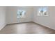 Spacious bedroom with wood-look floors and large window at 651 Jungle Queen Way, Longboat Key, FL 34228