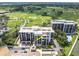 Aerial view of the condo building and golf course with water views in the distance at 6 Belleview Blvd # 706, Belleair, FL 33756