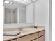 Bathroom with a single sink vanity, framed mirror and updated light fixtures at 6 Belleview Blvd # 706, Belleair, FL 33756
