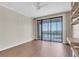 Bedroom with wood laminate floors, a sliding glass door to a balcony and built in shelving at 6 Belleview Blvd # 706, Belleair, FL 33756