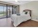 Bright bedroom with sliding glass doors to a balcony offering water views and wood laminate flooring at 6 Belleview Blvd # 706, Belleair, FL 33756